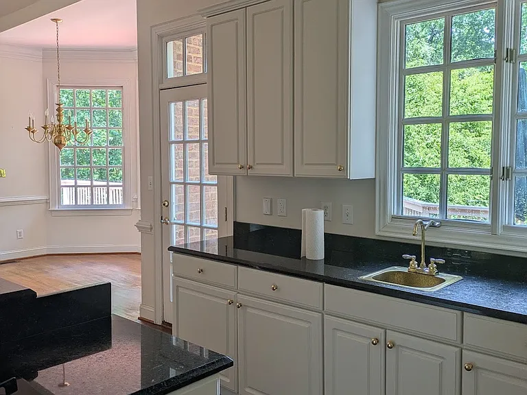 View of bar sink area with formal dining alcove beyond.
