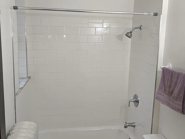 Full bath with tile surround.