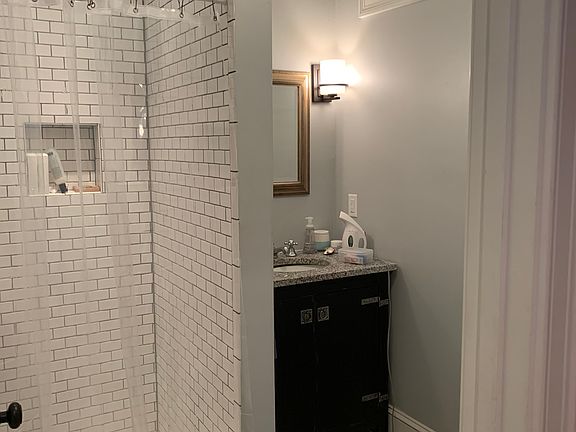 Tiled bath adjacent to master bedroom; a window that lets natural light in through the hallway, adds architectural charm and ambiance.