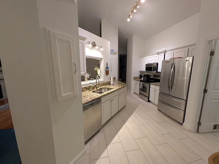 Kitchen
Spacious kitchen with new tile flooring, granite countertops, stainless steel appliances, abundant cabinets, and pantry storage. A cutout overlooks the living room, providing a view to the entertainment area- great for entertaining guests.