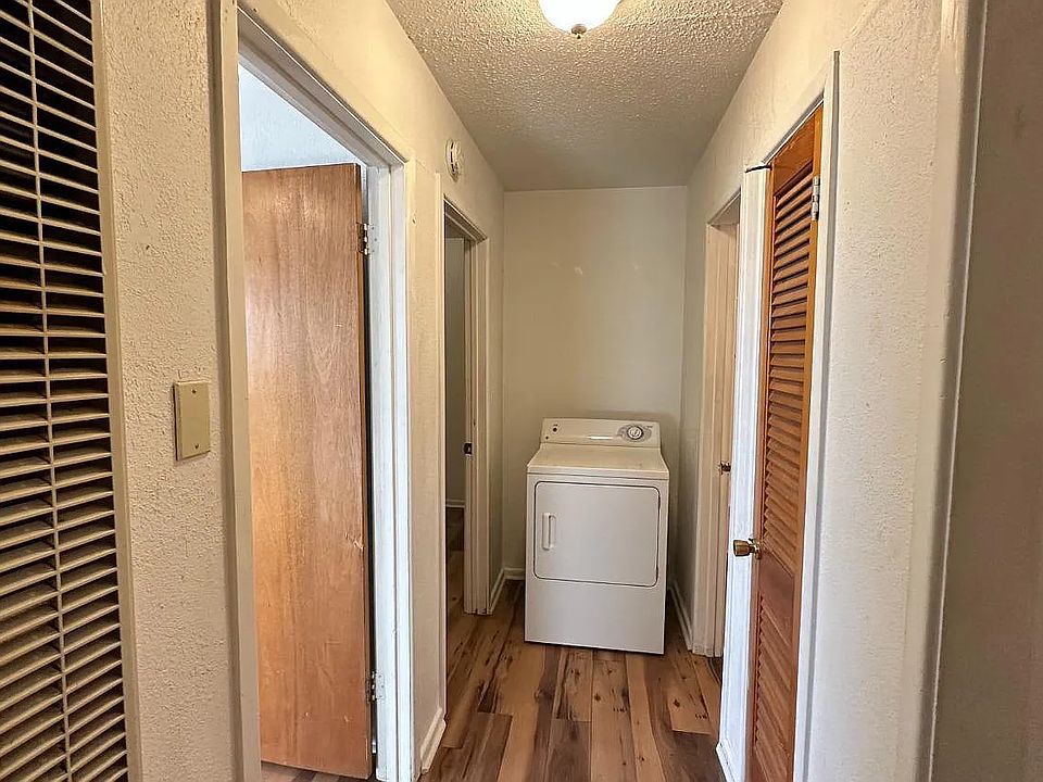 Hallway connecting the living areas, with a washer and dryer conveniently located nearby.
