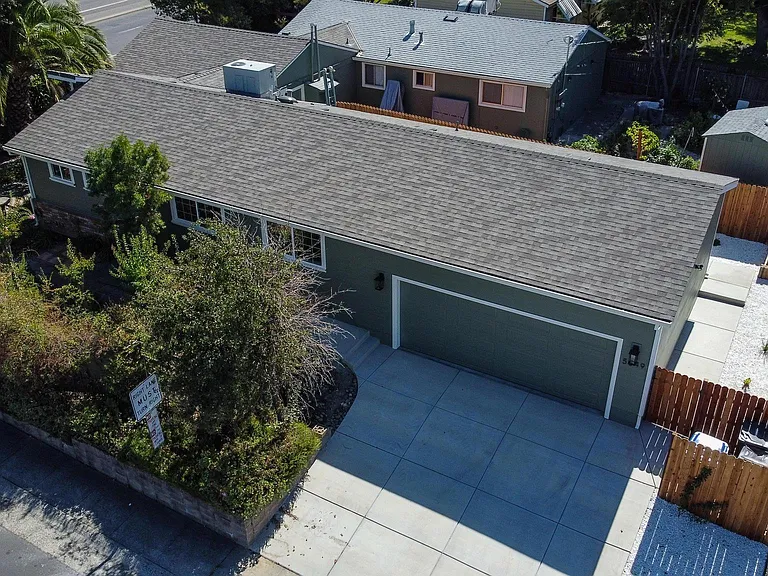 Arial of property. Dark grey roof is this address/listing. Parking in front of or in garage only.