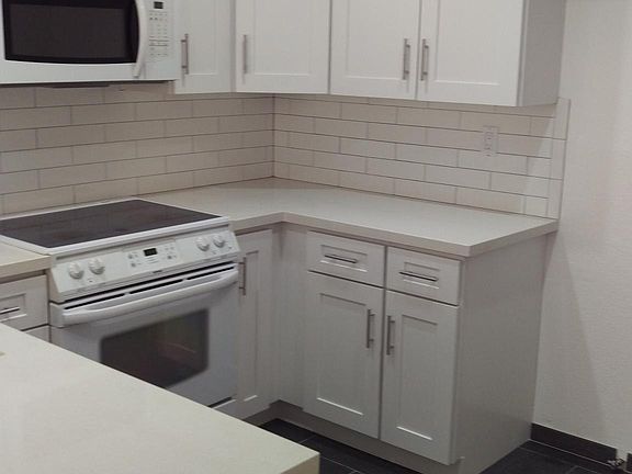 Brand new kitchen. Cabinets, quartz counter, sink and tile