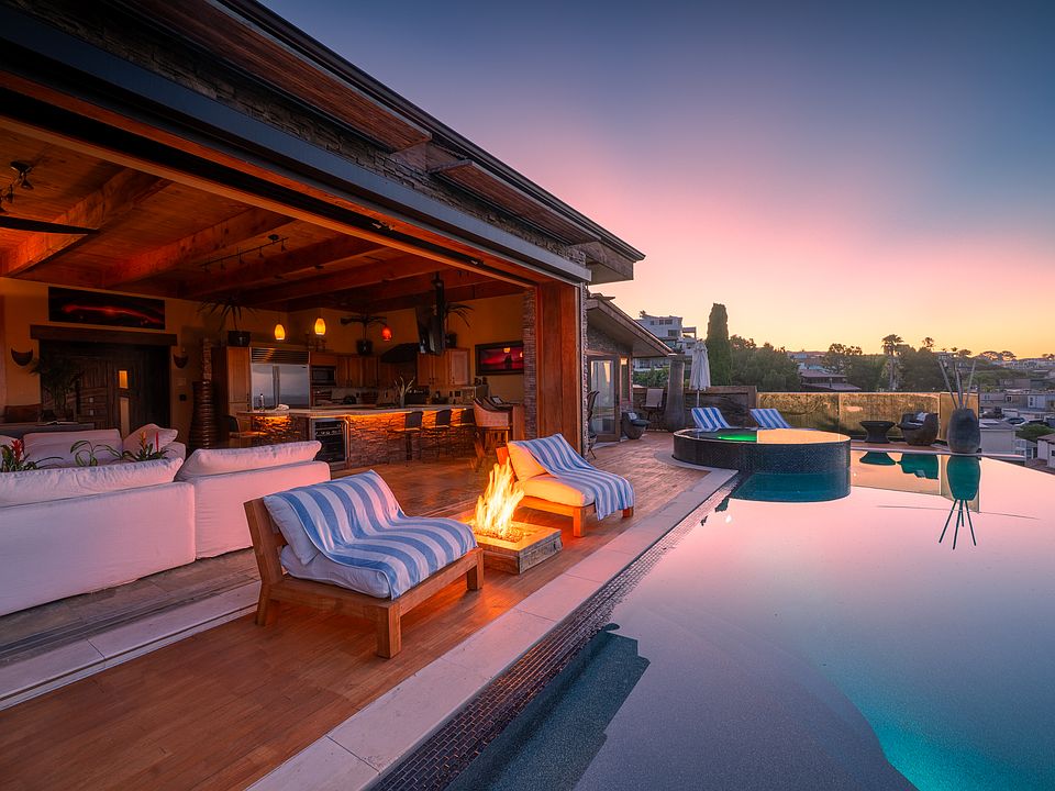 Pool Deck with hot tub and firepit. Twenty foot sliders lead into the great room. Masterbedroom is in the far ground leading out to the hot tub.