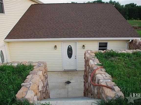 Back door has a cement deck and stone wall for grilling out