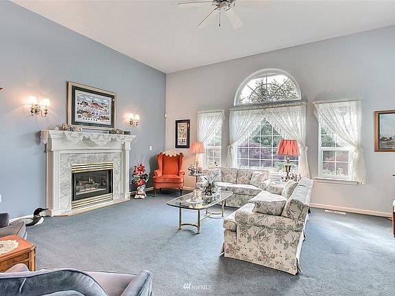 As you enter you will find on your right an amazing formal living room with 11' cathedral ceilings, marble gas fireplace and plenty of windows bringing in all the light. >