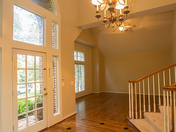 Welcoming two story Foyer boasts gorgeous inlaid hardwood floors, arched palladium window, updated neutral paint, crown moulding and eye-catching light fixture.
