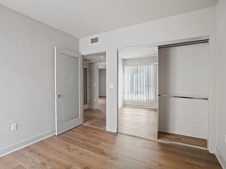 Bedroom with Mirrored Closet and Vinyl Flooring