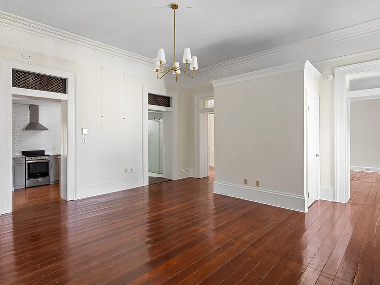 View of living room of kitchen, bathroom 1, and each bedroom doors.