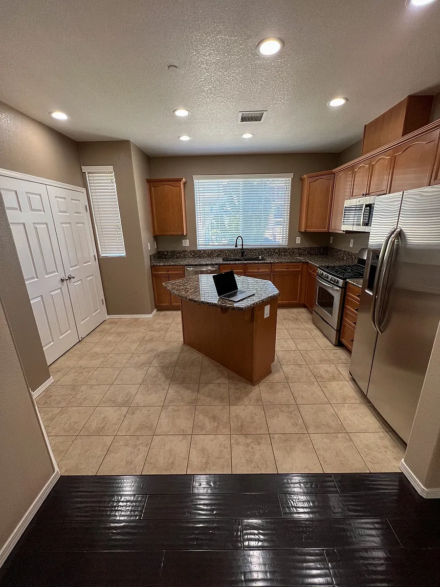 Kitchen fridge, oven, microwave sink & pantry doors... looking into kitchen from dining area. - 3109 Sterling Ridge Cir