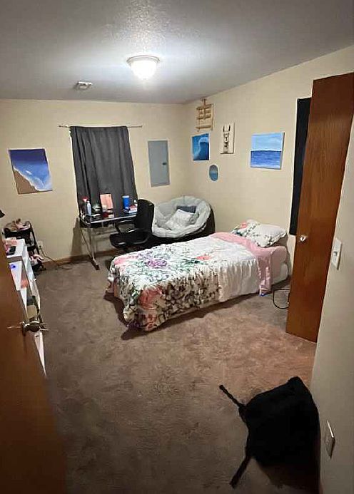 This spacious bedroom offers a serene retreat with ample natural light, soft neutral tones, and generous floor space for comfort and flexibility