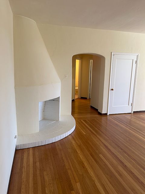 Living room with fireplace, refinished hardwood floors.