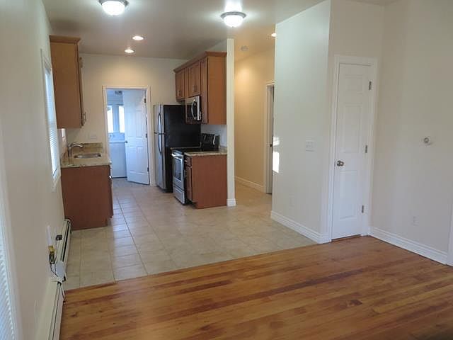 Living room opens to dinette area and kitchen. Hallway leads to master bedroom and to bathroom.