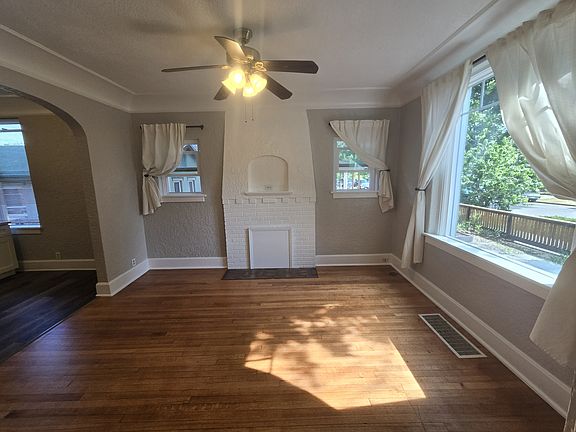 Spacious livingroom with refinished hardwood floors. Original 1905 fireplace structure adds charm.