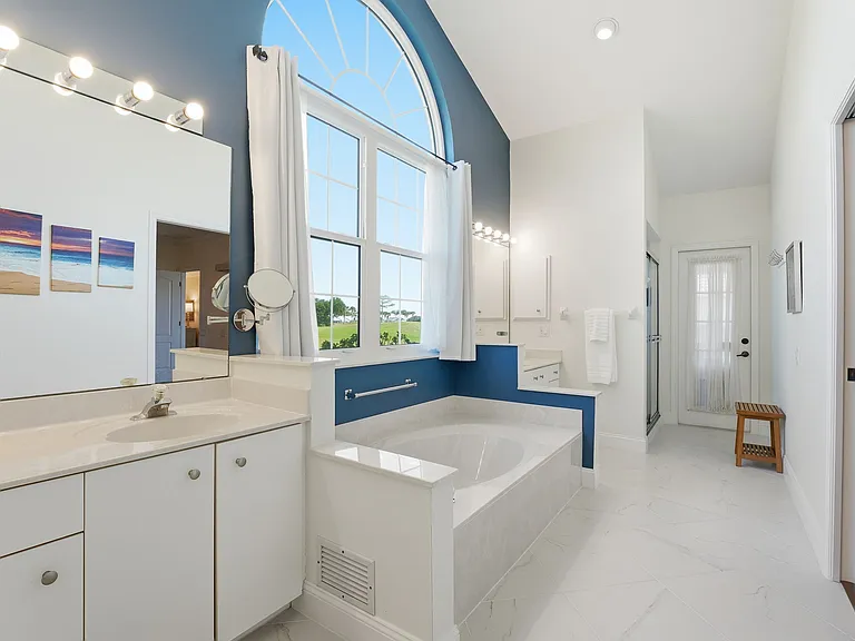 Large primary bathroom with dual sinks, walk-in shower, large bathtub, & separate water closet
