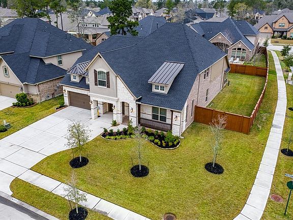 Many details to love - stained railings on the front porch, dormers, stained shutters, stone and brick facade.