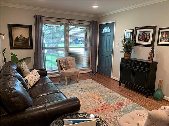 Charming living room with Floor-to-ceiling double paned windows with great view of front yard. Crown molding & recessed lights.