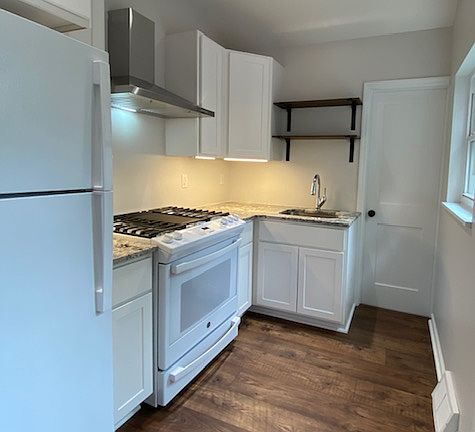 Newly renovated kitchen with gas stove, recessed lighting, and white cabinetry