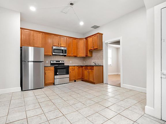 Large size kitchen with new appliances, recessed lights & room for table.