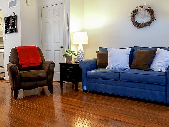 Spacious living room (view from entry), door to basement and kitchen in background.