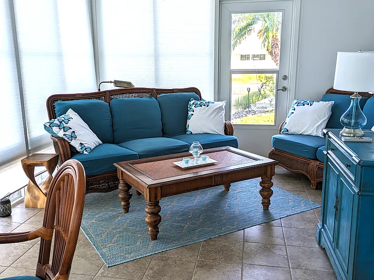 Right side of Lanai with sofa & loveseat - blinds closed -door to exit to right patio -