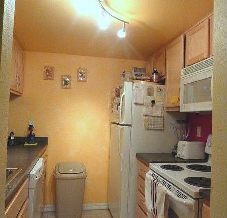 Galley kitchen with track lighting and all appliances stay!