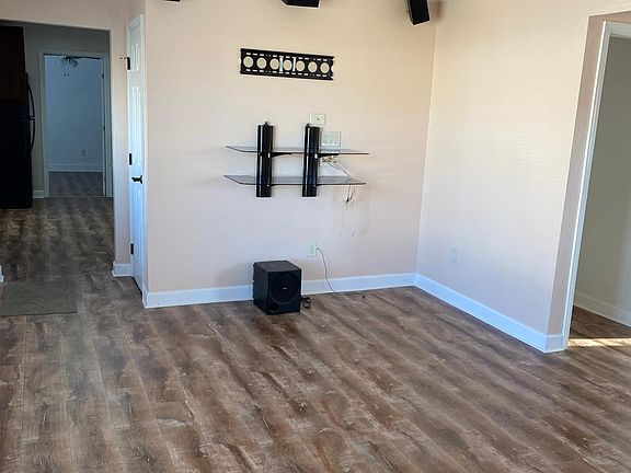 Front side of the living room with a wall mount TV set up and surround sound.