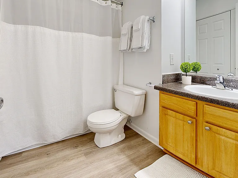 Bright bathroom with granite counters and bathtub