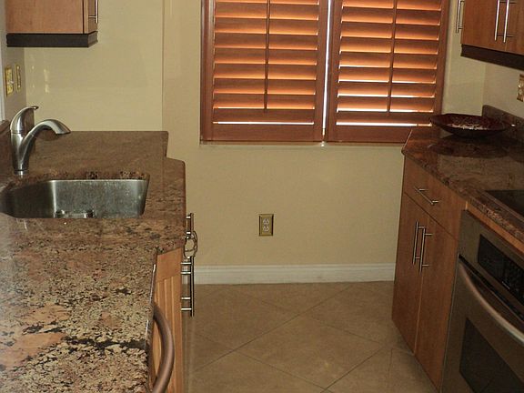Kitchen with nice cabinetry and countertop electric cook top/built in oven, dishwasher, refrigerator and microwave & tile floor