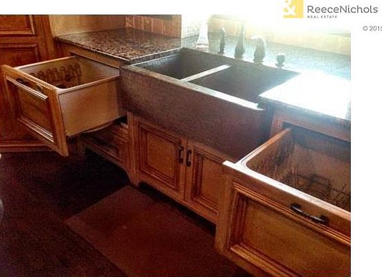 Two drawer dishwasher located on each side of the copper farm sink.