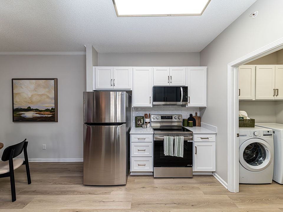 Kitchen and laundry room with hardwood-style flooring & modern cabinetry