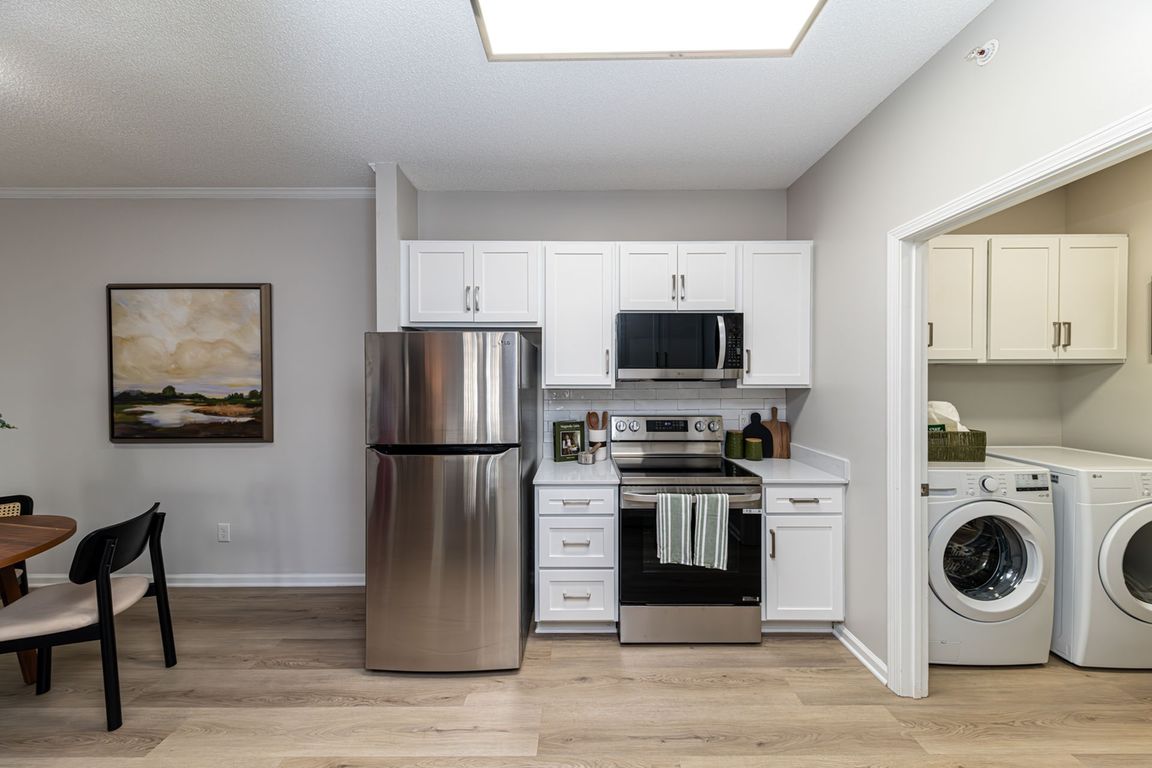 Kitchen and laundry room with hardwood-style flooring & modern cabinetry