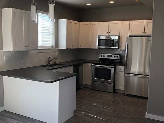 Contemporary Kitchen - all stainless appliances, quartz solid surface counter, and tile backsplash