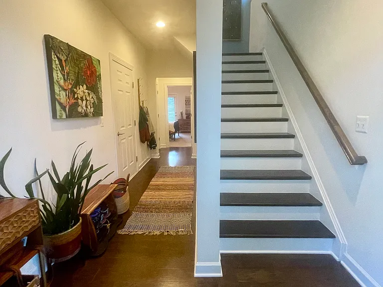 Hall to entry level bedroom, garage and storage closets and stairs to main level