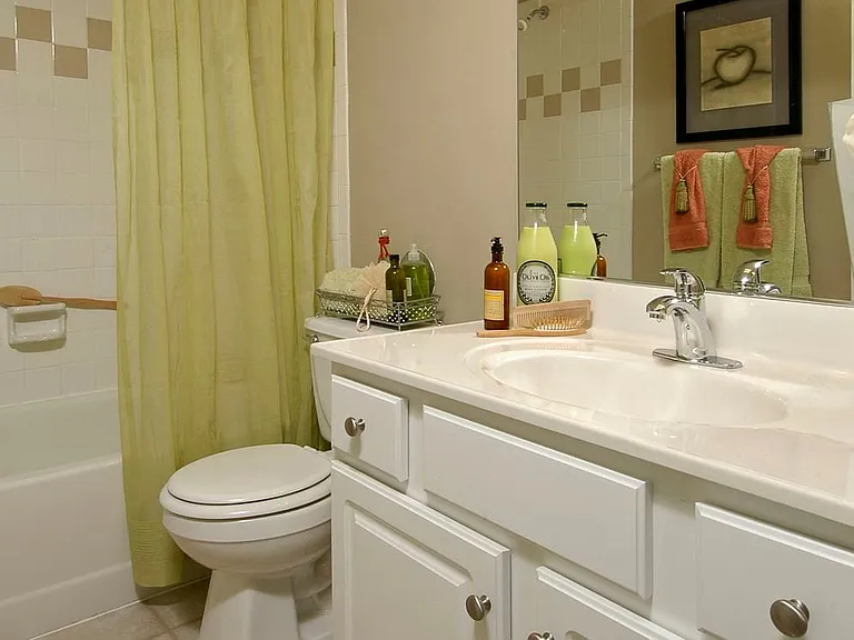 Classic Woods bath with white countertops, white cabinetry, and tile flooring