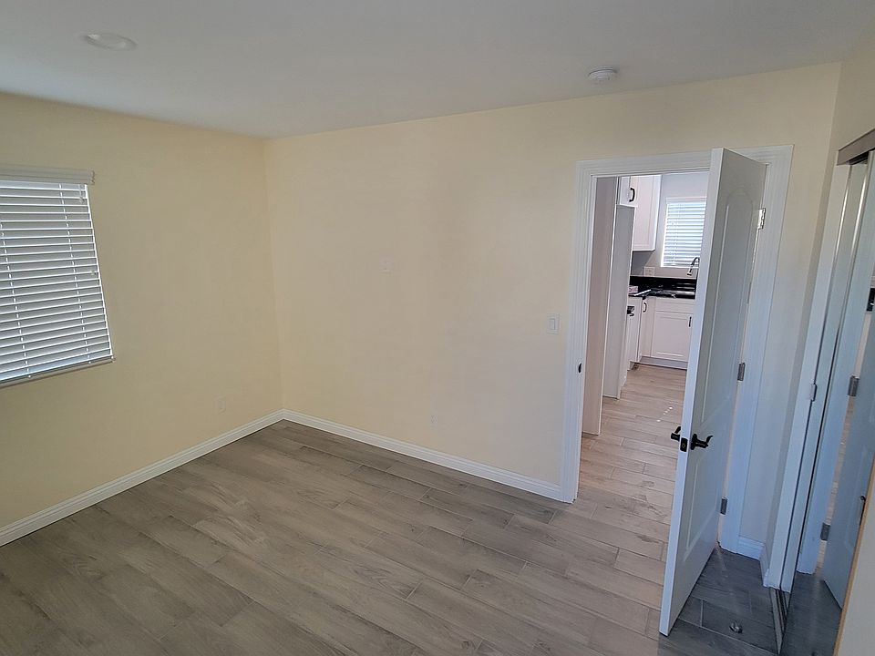 Across bedroom showing closet and door to hallway and kitchen.