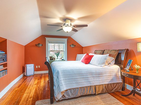 Step into the warm elegance of this newly remodeled master bedroom, painted in the inviting 'Pretty Parasol' hue that perfectly complements the original fir floors. To enhance warmth and comfort, a new, generously sized rug has been added.