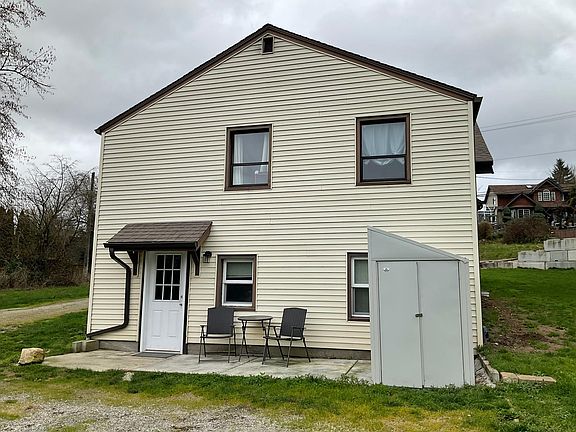 Lower unit entrance with patio and outdoor storage.