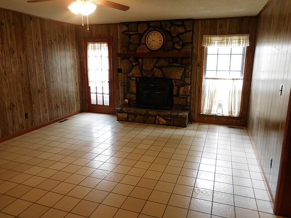 Den with stone fireplace.