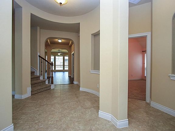 Look at this elegant yet warm and welcoming entryway with a stunning rotunda, beautiful oversized tile floors, and wrought iron staircase.  Lots of WOW factor here!