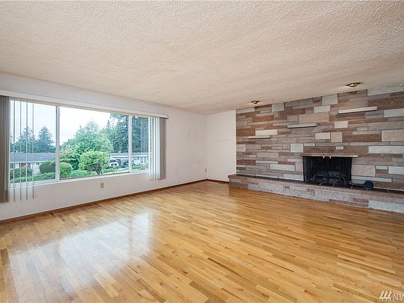 Formal living room with full-height stone wall around fireplace