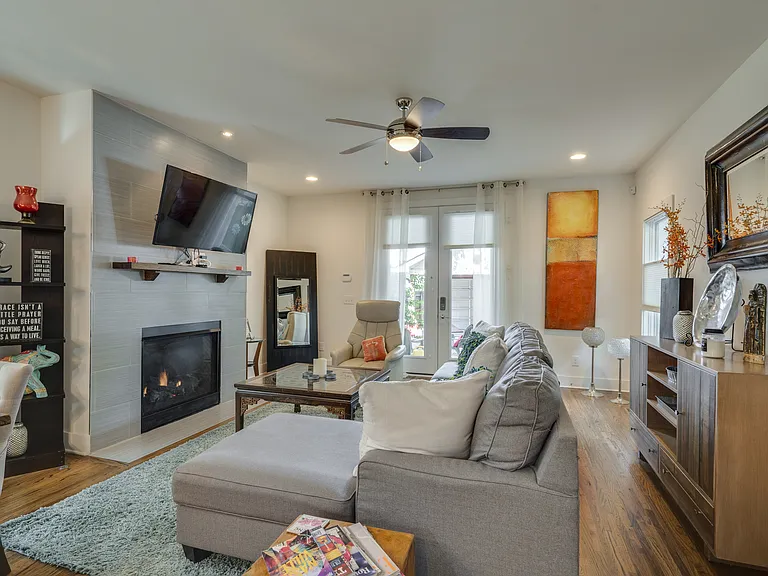 Spacious living room featuring a cozy gas fireplace, large Roku TV, comfortable chaise sofa, and recliner, creating the perfect place to unwind after a day exploring Nashville or working remotely.