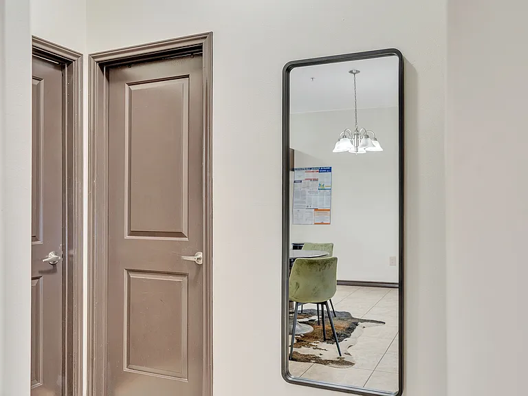 A wall-mounted mirror in a hallway at La Joya Apartments, Laredo, Texas, reflecting the surrounding space