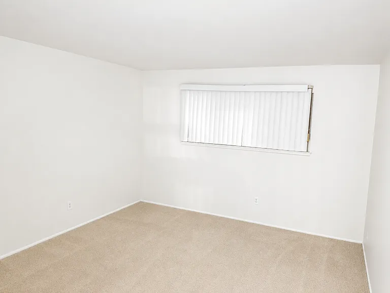 Spacious master bedroom with blackout curtains.