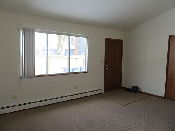 Living Room, unfurnished. Note large window; also ceiling goes up at an angle creating more spacious feel