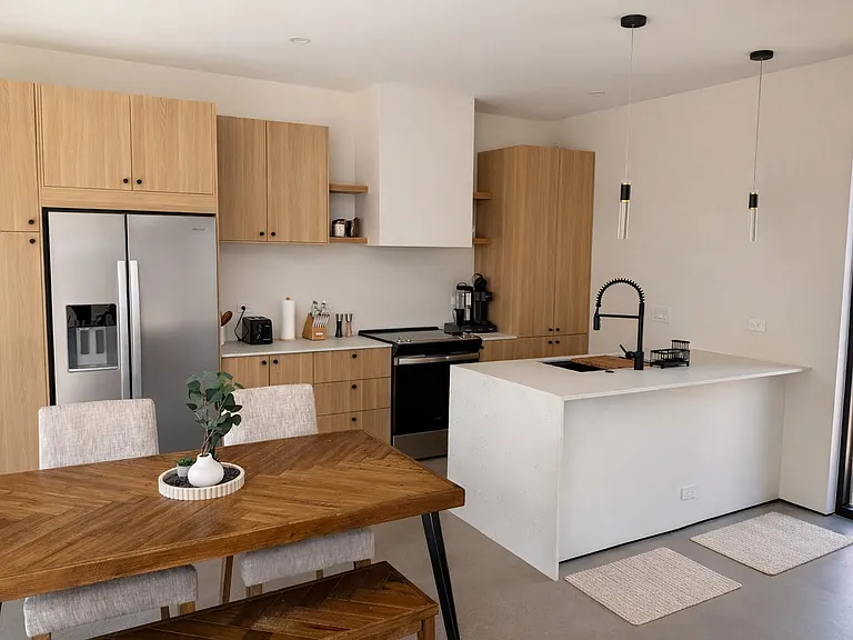 Open-concept kitchen with a waterfall island, modern appliances, and a cozy dining area_perfect for entertaining.