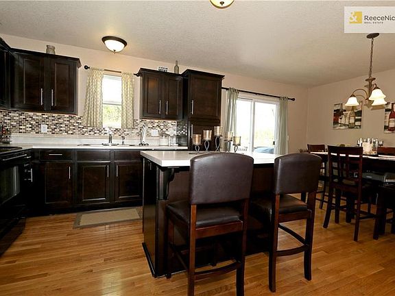 Open concept kitchen with dark stained cabinets and wood floor