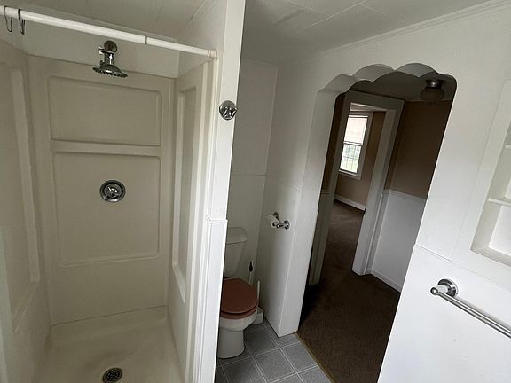 Bathroom view looking out into the dining area. Door is on closet connected to the bathroom.