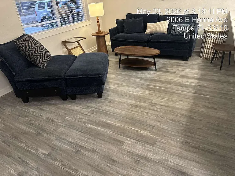 Stylish living room with bold navy sofa and warm wood flooring.