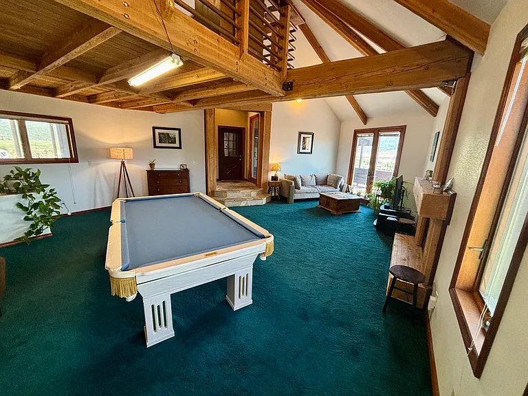 Game room with loft above pool table